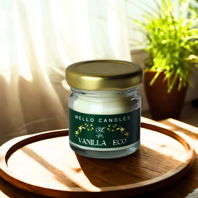 Jar of Mello Candles Vanilla Eco candle on a wooden surface with a plant in the background