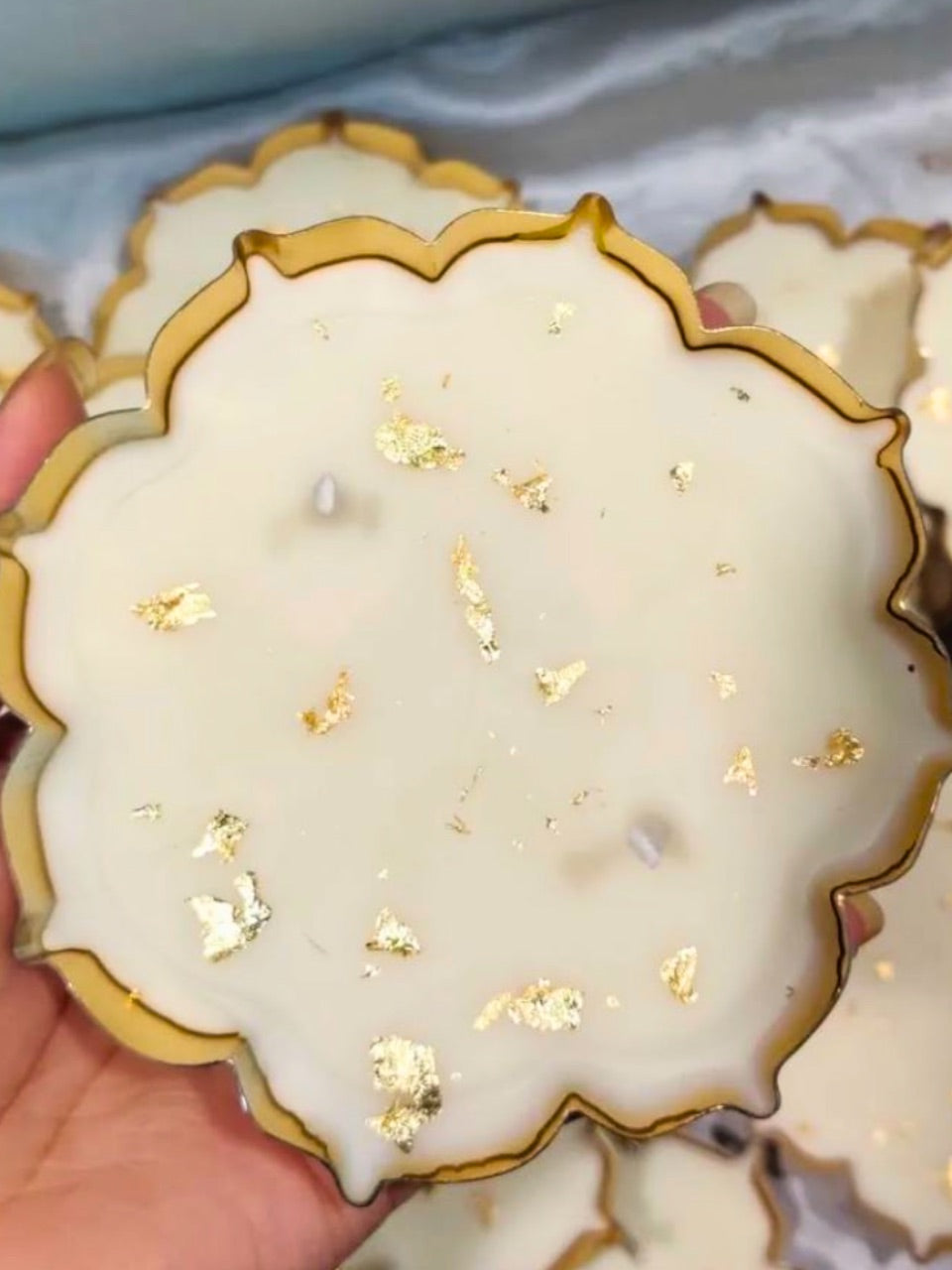 Decorative urli candle with gold accents held by a hand