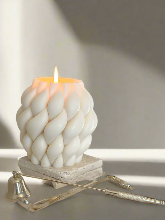 Aesthetic spiral mould candle. Burning and placed on marble pieces. 